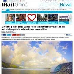 Mind the pot of gold: Surfer rides the perfect wave just as an astonishing rainbow breaks out aournd him