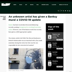 An unknown artist has given a Banksy mural a COVID-19 update